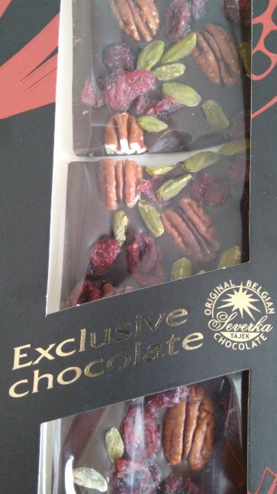 Fotografie - hořká čokoláda formovaná s pekanovými ořechy, pistáciemi a brusinkami